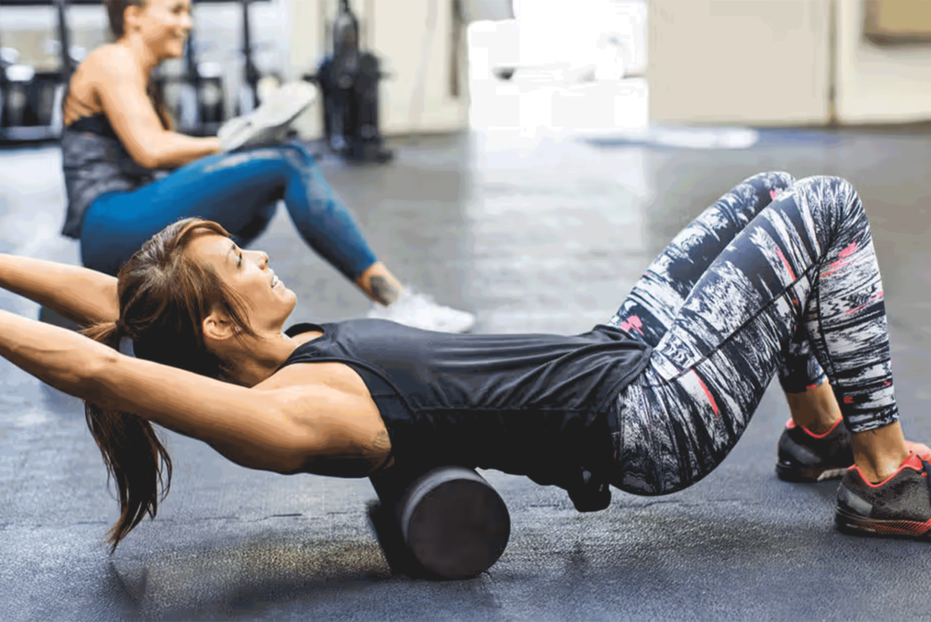 Fitness Enthusiast Using A Foam Roller To Exercise At The Gym
